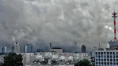 Dunkle Regenwolken über den Hochhäusern und Dächern Frankfurts