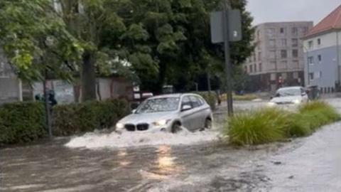 Autos fahren durch eine überflutete Straße