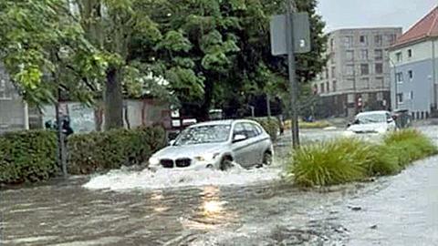 Autos fahren durch eine überflutete Straße