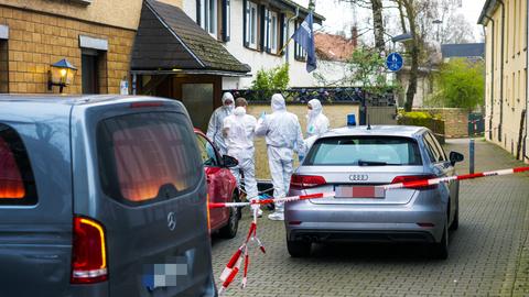 Mitarbeiter der Spurensicherung in weißen Anzügen vor dem Eingang eines Lokals