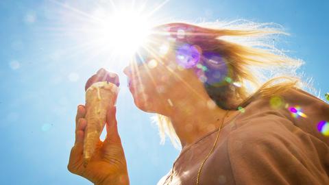 Eine Frau isst ein Eis in der Sonne