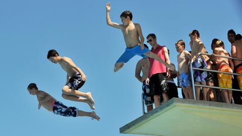 Jugendliche springen vom Turm des Mühltalbads in Darmstadt-Eberstadt