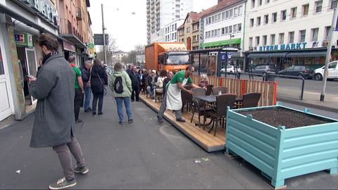 Ein Gastronom stellt einen Stuhl auf die neuen Planken