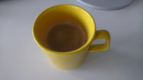 Gelbe Tasse mit Kaffee darin