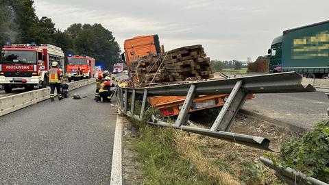 Ein Lastwagen mit Holzbrettern beladen steht in einem Baustellenbereich, die Mittelschutzplanke ist verbogen