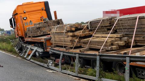 Ein Lastwagen mit Holzbrettern beladen steht in einem Baustellenbereich, die Mittelschutzplanke ist verbogen