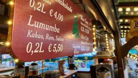 Ein Schild an einer Glühweinbude auf dem Frankfurter Weihnachtsmarkt. Auf ihm steht geschrieben: "Lumumba: Kakao, Rum, Sahne - 0,2 Liter für 5,50 Euro"