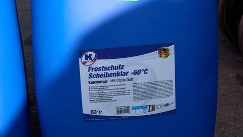 "Frostschutz Scheibenklar -60 Grad" steht auf einer blauen Plastiktonne.