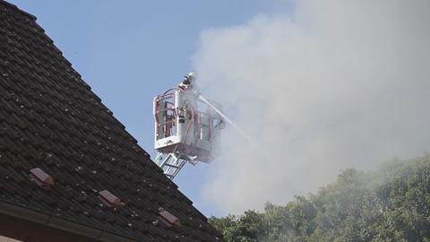 Feuerwehrmann auf Drehleiter mit Schlauch