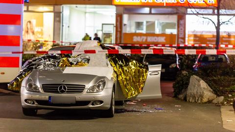 Ein mit Thermofolie abgedecktes und Polizeisperrband versehenes Auto am Tatort im Hanauer Stadtteil Kesselstadt - das Auto des getöteten Vili Viorel Păun. 