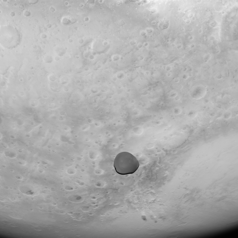 Der Marsmond Deimos als dunkler Punkt vor der hellen Marsoberfläche