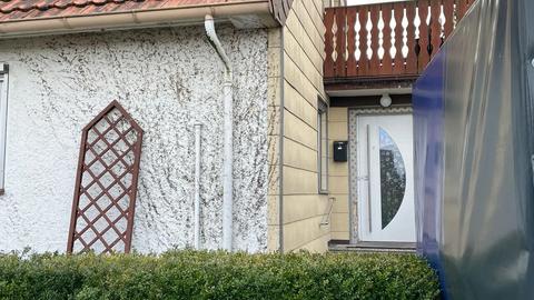 Wohnhaus mit Eingangstür, an der ein Polizei-Siegel hängt