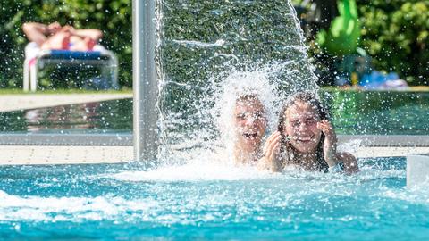 Jugendliche kühlen sich im Freibadbecken ab