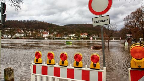 Schild mit Aufschrift "Hochwasser" und Absperrung