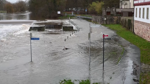 Von den Gehwegen ist nichts mehr zu sehen, weil sie überflutet sind. Straßenschilder ragen aus dem Wasser.