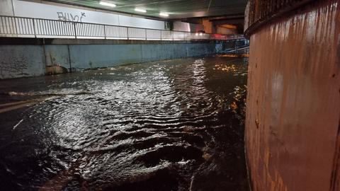 Das Wasser steht knietief in einer Unterführung.