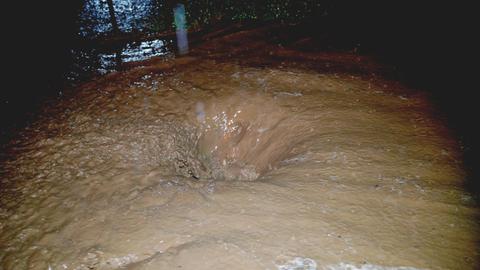 Wassermassen und Schlamm laufen in Kanal