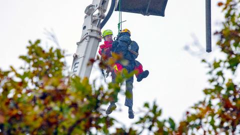 Ein Höhenretter der Feuerwehr lässt sich an einem Seil zu dem verletzten Mann hinab.