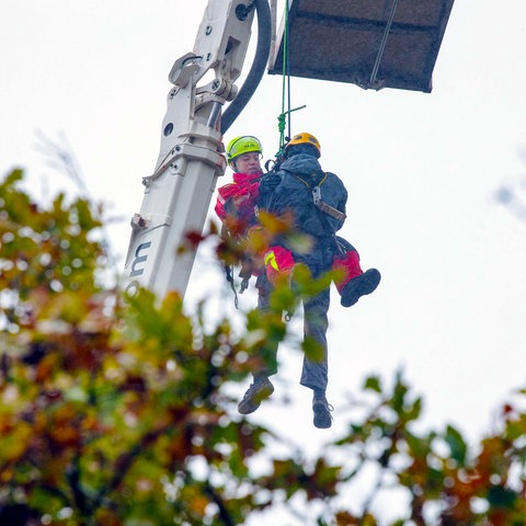 Ein Höhenretter der Feuerwehr lässt sich an einem Seil zu dem verletzten Mann hinab.