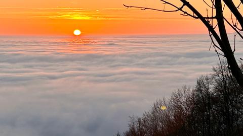 Die Sonne geht auf und im Tal liegt der Nebel.