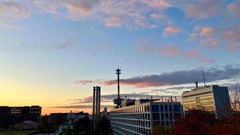 hr-Funkhäuser in Frankfurt im Sonnenaufgang, Himmel in gelb-orange-hellblau mit Schäfchenwolken