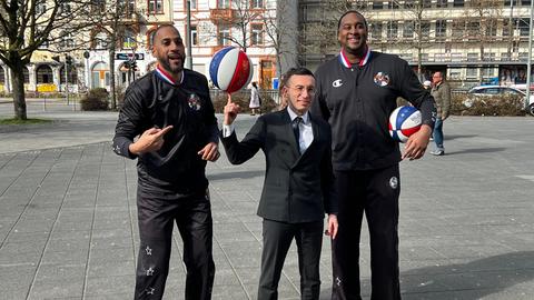 Frankfurts Oberbürgermeister Mike Josef jongliert einen Basketball, dahinter zwei Mitglieder der Harlem Globetrotters.