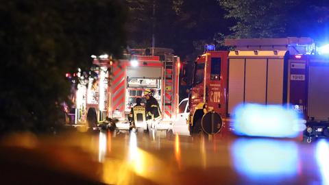 Autos von Einsatzkräften mit Blaulicht auf Straße bei Dunkelheit