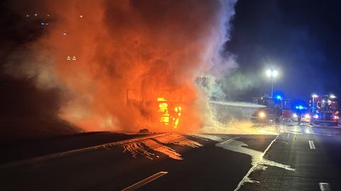 Brennendes Lkw-Führerhaus, daneben Einsatzkräfte in Löschaktion