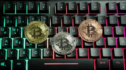 Bitcoin-Zeichen liegen auf einer Computertastatur.