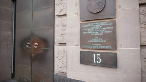 Das Landgericht Saarbrücken von außen mit Schild, das die Gerichtsbarkeiten auflistet