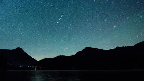 Leider nicht in Hessen: Eine Sternschnuppe der Leoniden leuchtet am Himmel über dem Walchensee in Bayern. 