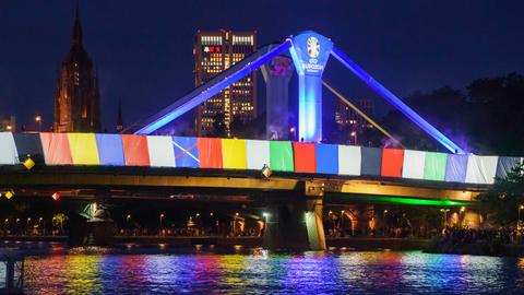 Eine Brücke ist mit bunten Flaggen dekoriert.