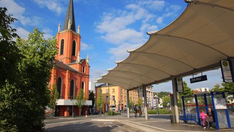 Leere Bushaltestelle in Limburg, dahinter eine Kirche.