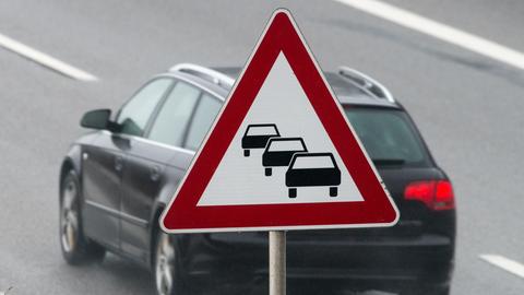 Auto fährt unter Stau-Schild hindurch