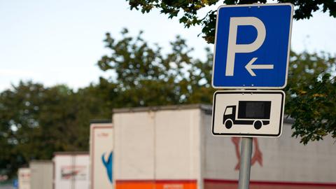 Geparkte Lastwagen stehen auf einem Autobahnrastplatz.