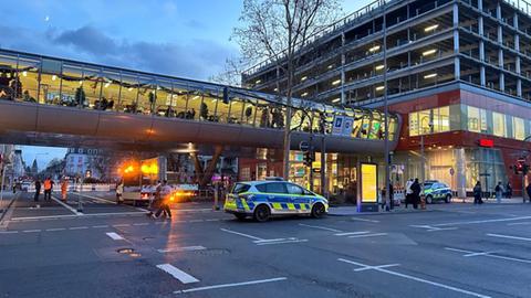 Gesperrte Straße vor dem Luisenforum in Wiesbaden, darüber verglaste Fußgängerbrücke, unten Polizeiwagen