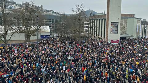 Tausende Menschen mit Plakaten und Fahnen vor einer Kirche in Marburg; Aufnahme von oben