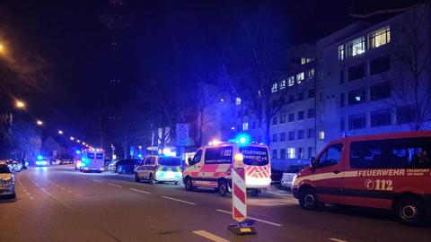 Feuerwehr- und Polizeifahrzeuge mit Blaulicht vor einem großen Gebäude