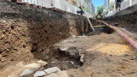 Erde - dazwischen Steine - in einem Graben, der von Bauarbeitern ausgehoben wurde