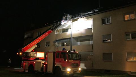 Die Feuerwehr mit einer Drehleiter an der Dachrinne.