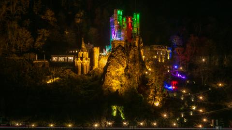 Burg Rheinstein in festlich-bunter Weihnachtsbeleuchtung im Dunklen