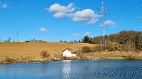 Kleiner Teich bei strahlend blauem Himmel, Sonnenschein und Schönwetterwolken