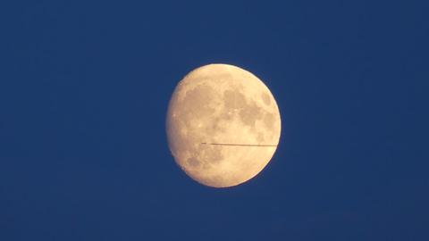 Flugzeug fliegt am fast vollen Mond vorbei