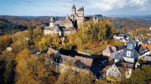 Drohnenaufnahme des Schlosses Braunfels mit seinen vielen Türmen, das auf einem Hügel über der Stadt Braunfels thront