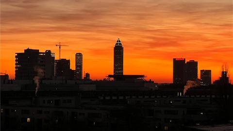 Die Skyline von Frankfurt vor orangenem Abendhimmel.