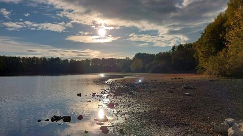 Sonnenschein fällt auf Steinufer mit Wasser