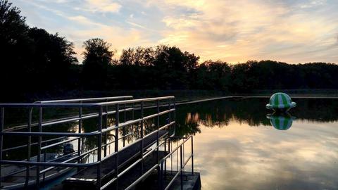 Foto eines Sees, der in der Abenddämmerung liegt.