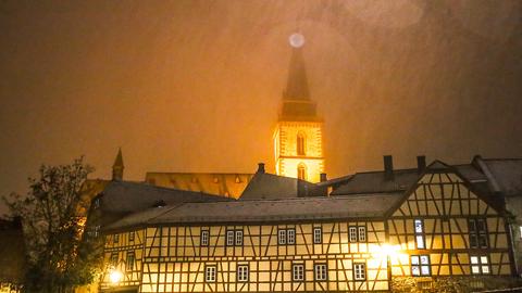 Blick auf Gebäude in der historischen Oberurseler Altstadt. Es ist dunkel und es gibt Schneeregen. 