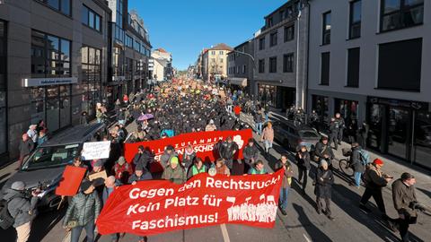 Spitze des Demonstrationszugs in Neu-Isenburg; Teilnehmende halten ein Banner mit der Aufschrift "Gegen den Rechtsruck! Kein Platz für Faschismus!" hoch; dahinter tausende Demonstrierende