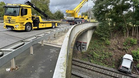 Auto im Gleisbett mit Abschlepper und Kran